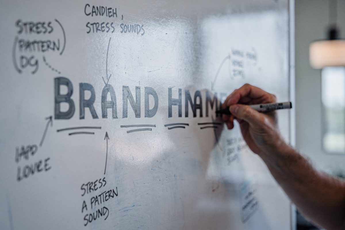 A whiteboard breaking a candidate name into syllables with handwritten sound notes.